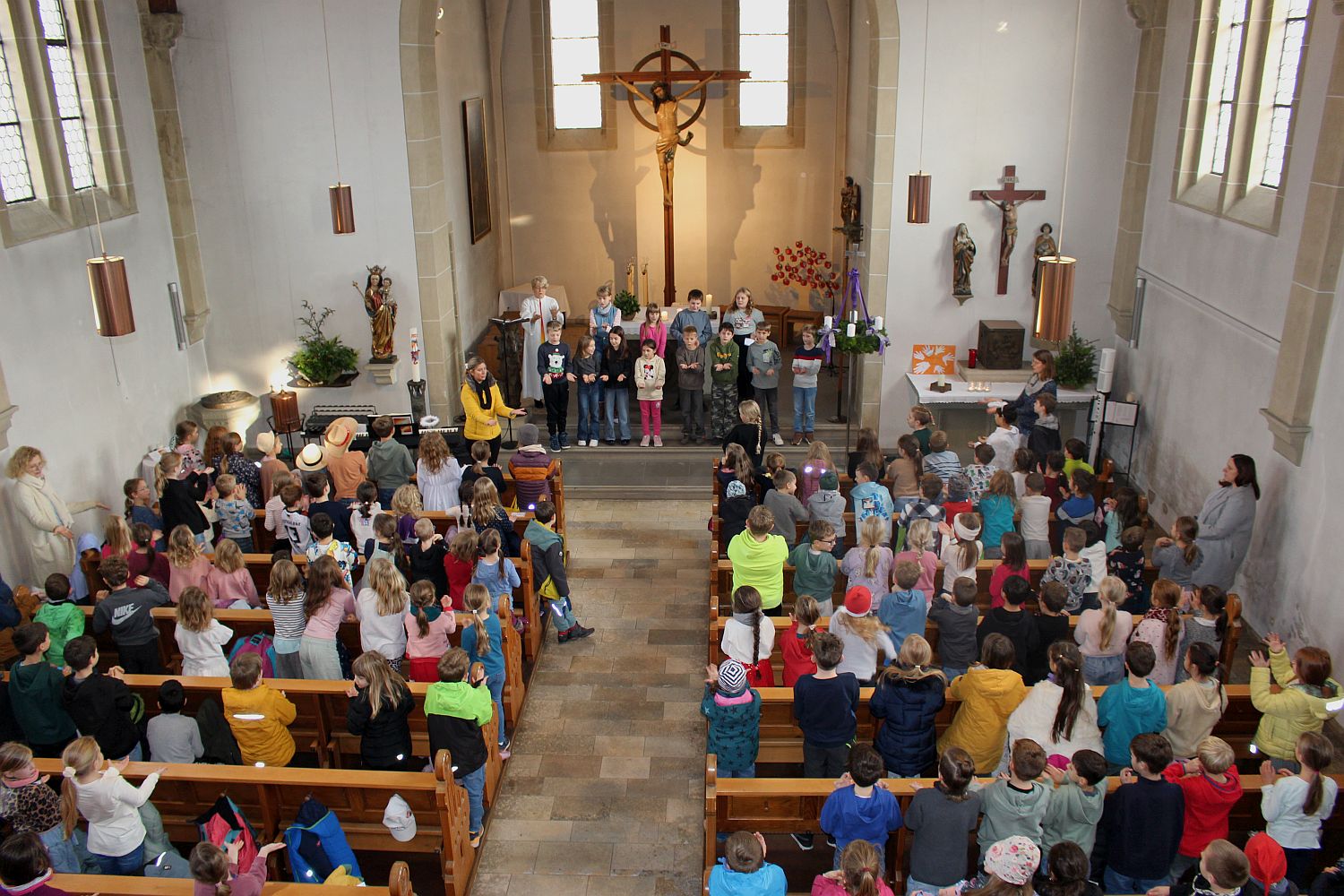 Foto von der Ampore, man sieht fast den gesamten Kirchenraum mit Kindern